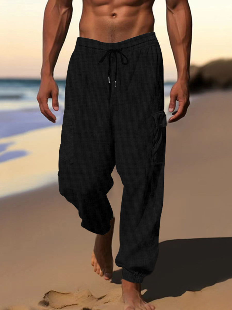 Black waffle knit joggers with drawstring and cargo pockets.