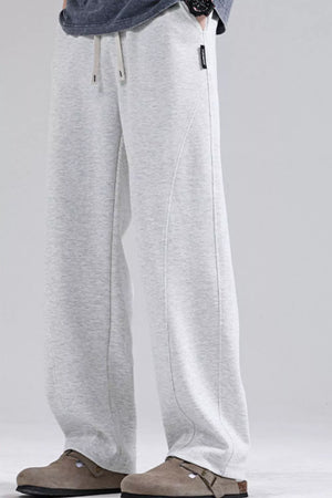 Men's light gray loose fit sweatpants with drawstring waist and curved seam detail.