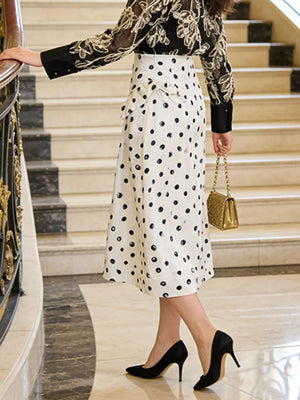 White polka dot midi skirt with ruffle detail and a black floral print blouse.