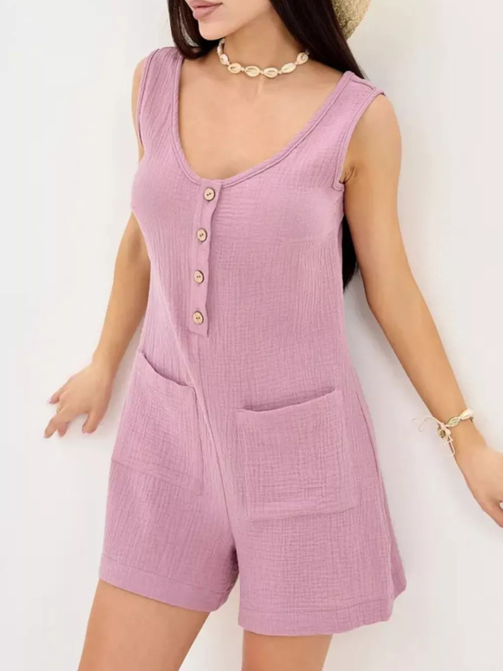 Button-down sleeveless cotton romper in purple with crinkled texture and patch pockets.
