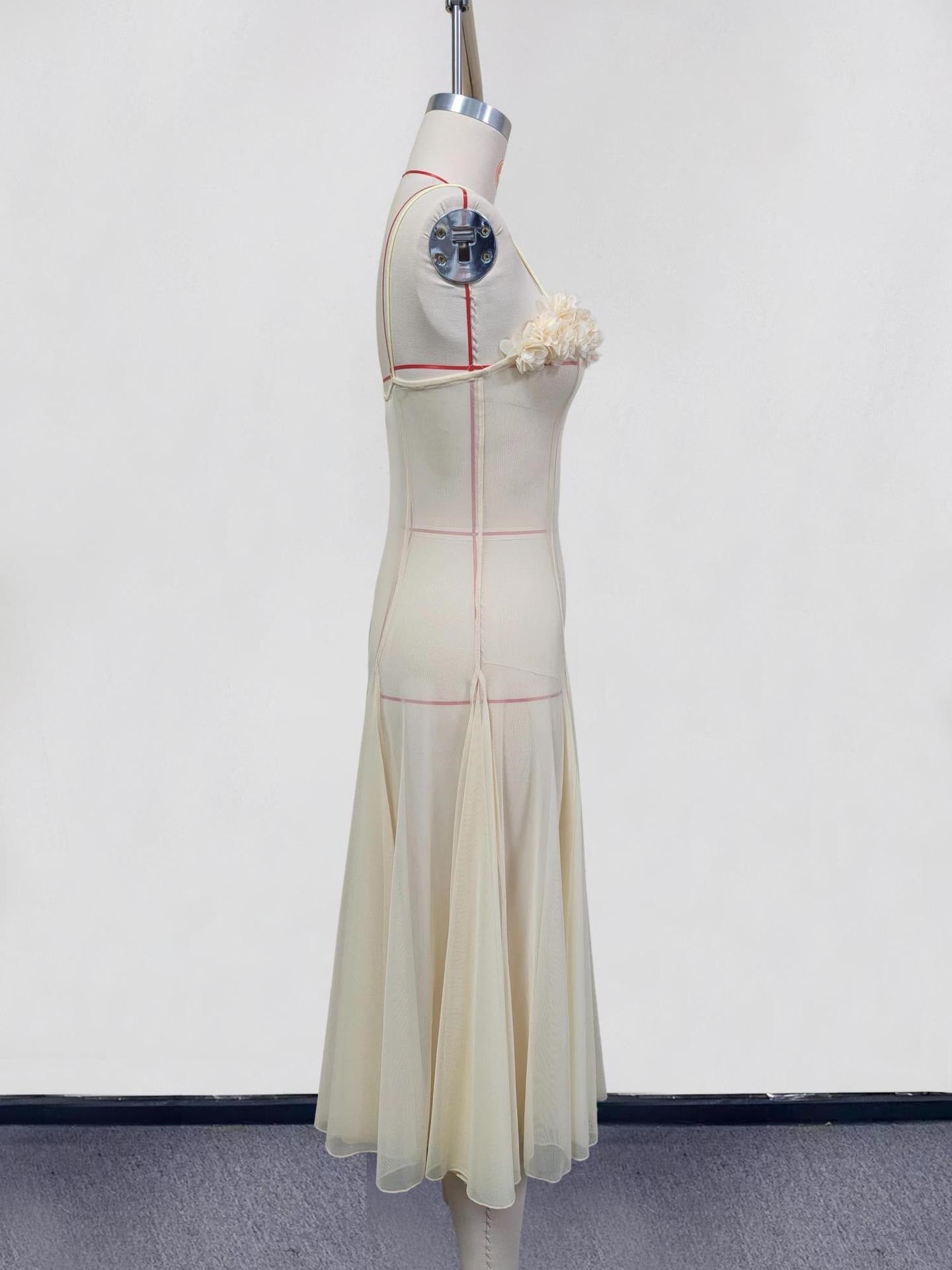 Cream slip dress with spaghetti straps and floral embellishment, sheer flowing skirt.