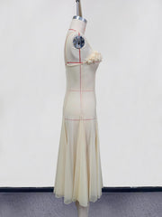 Cream slip dress with spaghetti straps and floral embellishment, sheer flowing skirt.