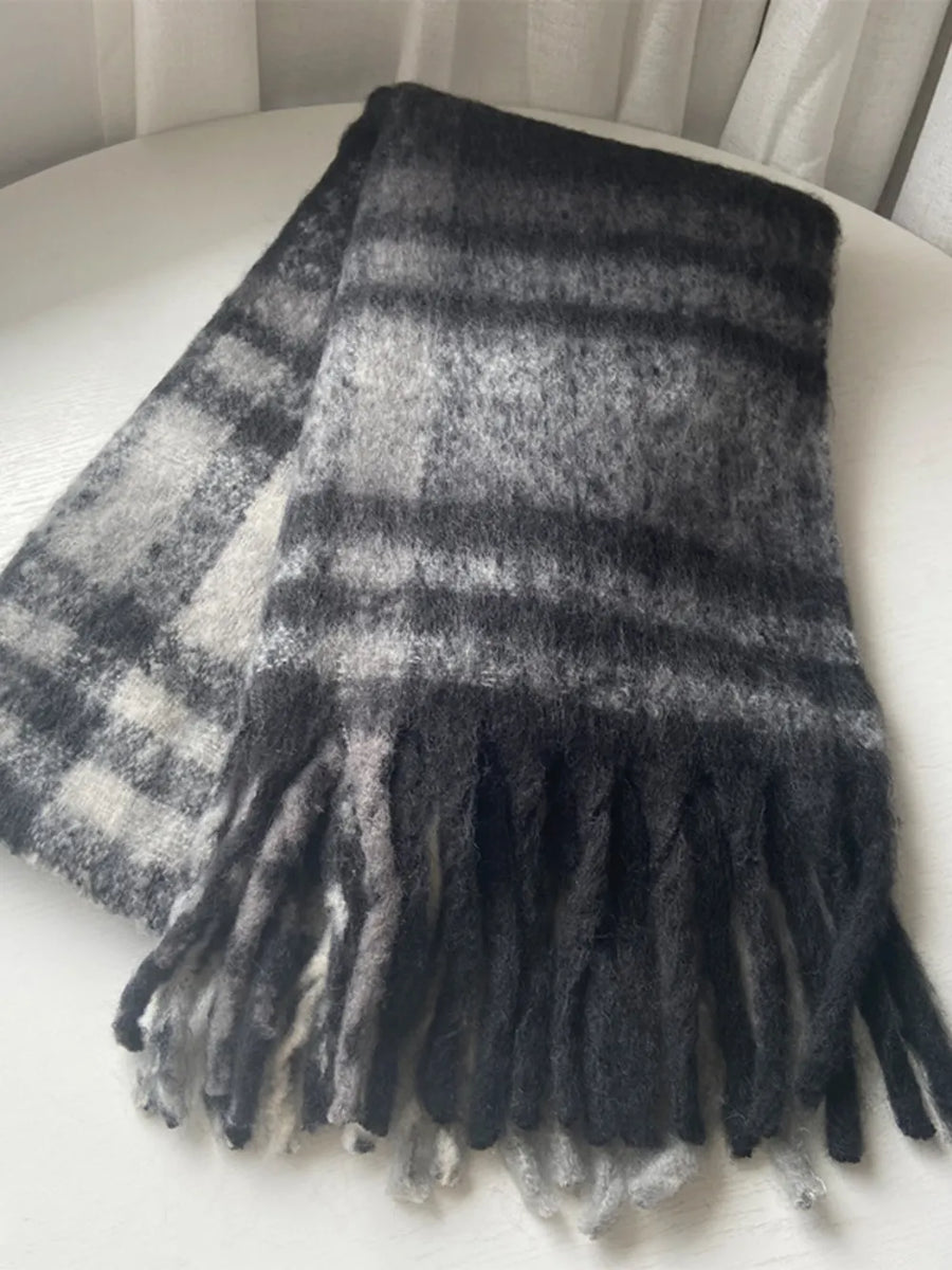 Textured plaid fringe wrap scarf in black/white/gray plaid with fuzzy texture and fringed edges.