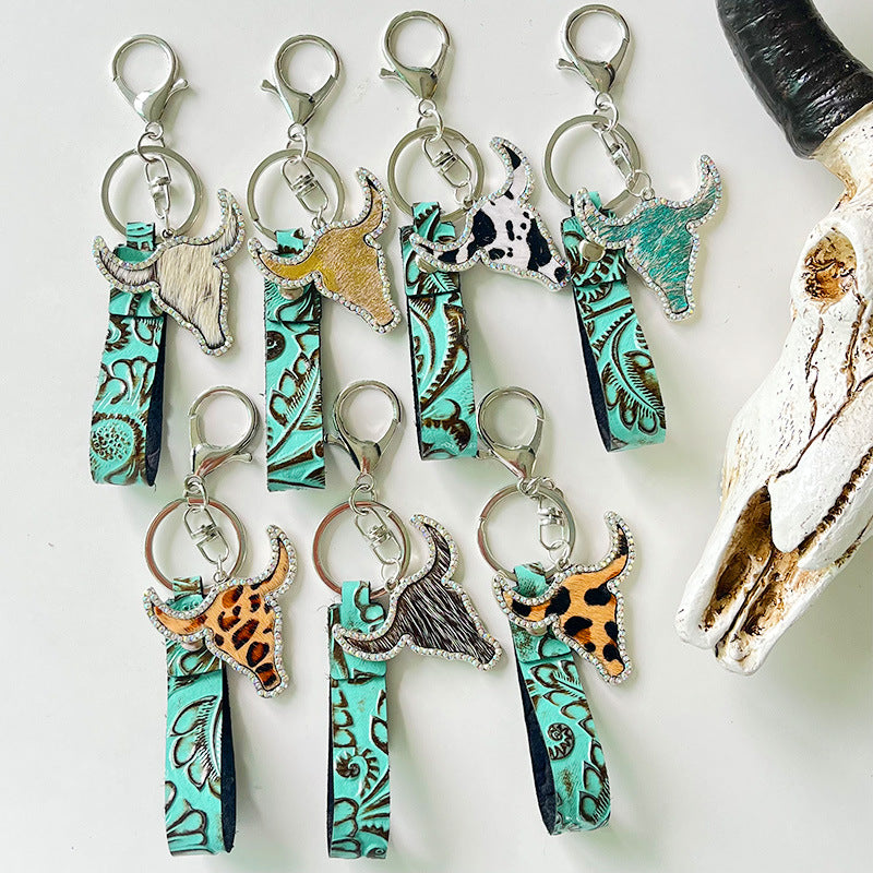 Embossed leather bull keychains with crystal accents in various animal prints and colors.