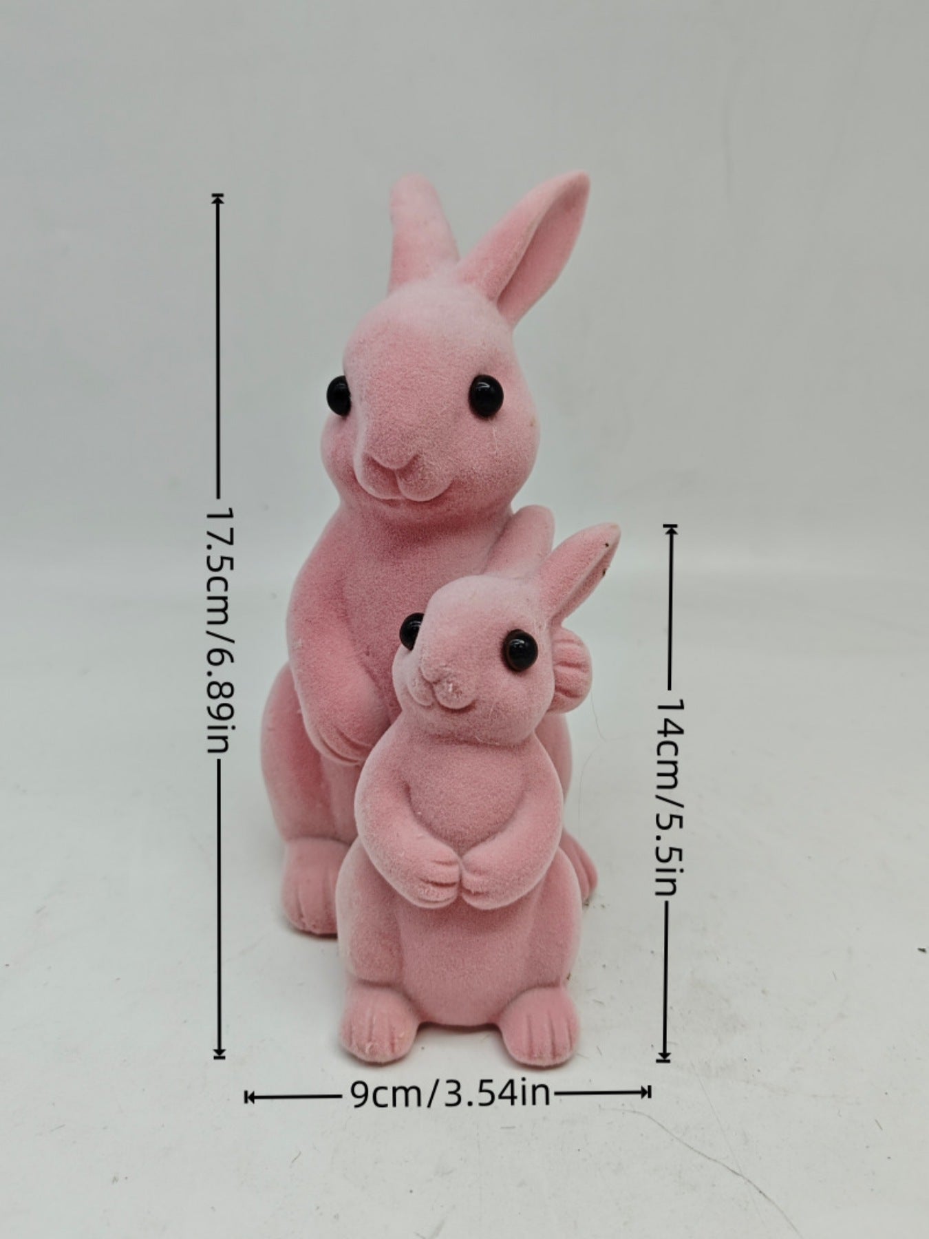 Charming pink flocked bunny decorative ornaments, one large and one small, with black eyes.