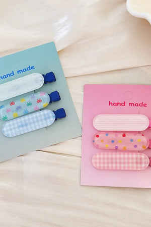 Pastel patterned acrylic hair clips trio with butterflies, dots, and gingham patterns.