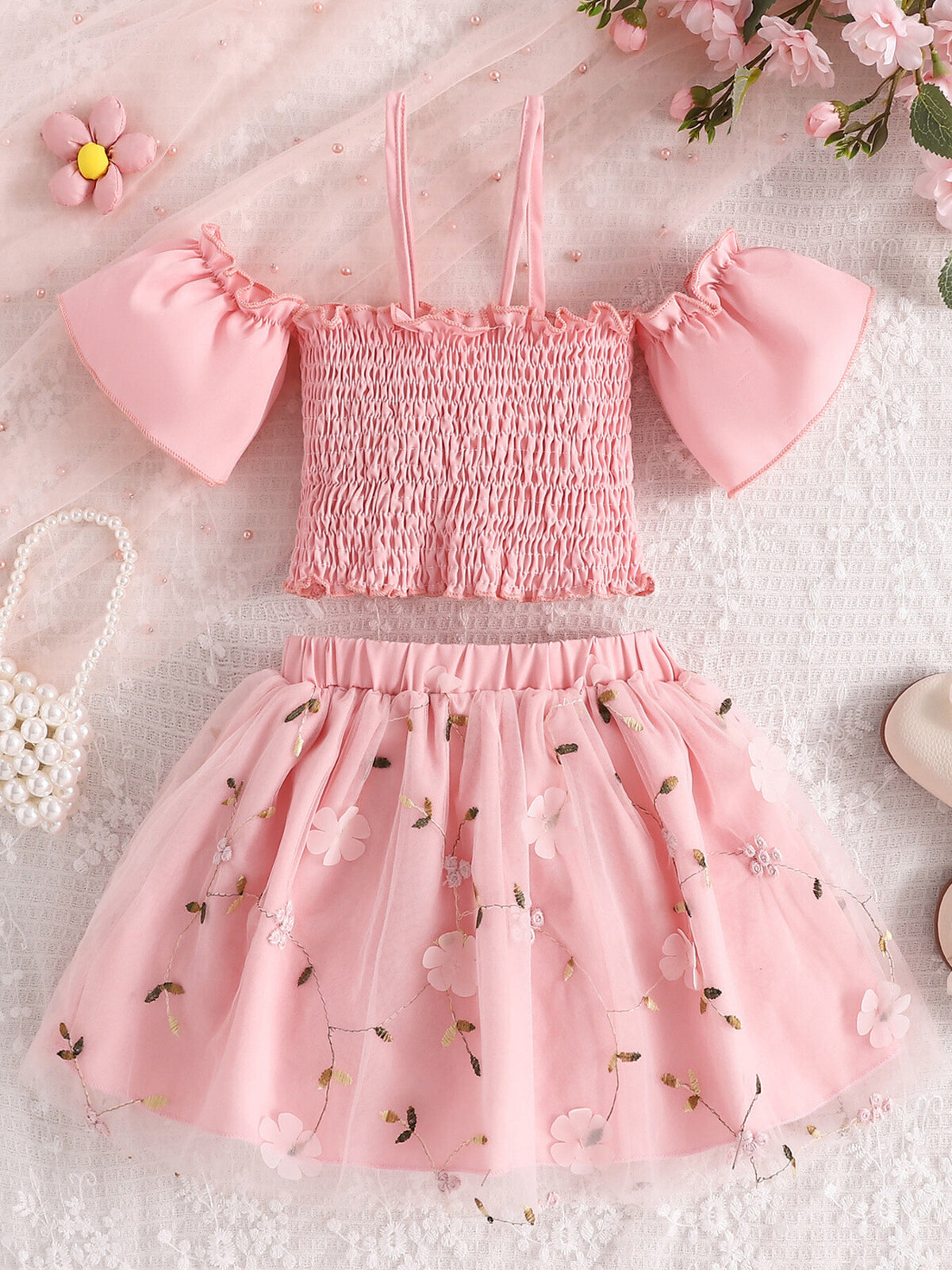Pink smocked off-shoulder top with ruffled sleeves and floral embroidered tulle skirt set.