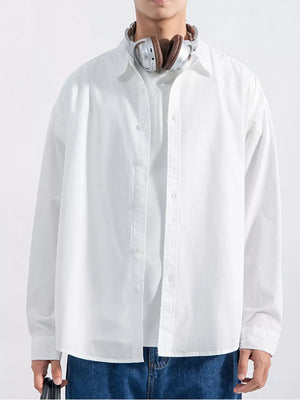 Men's white long sleeve button-up shirt with relaxed fit, styled casually.