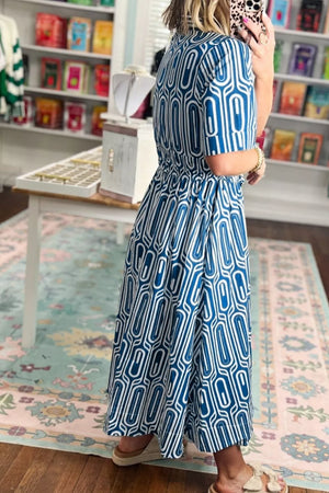 Blue and white geometric print midi dress with short sleeves and a cinched waist.