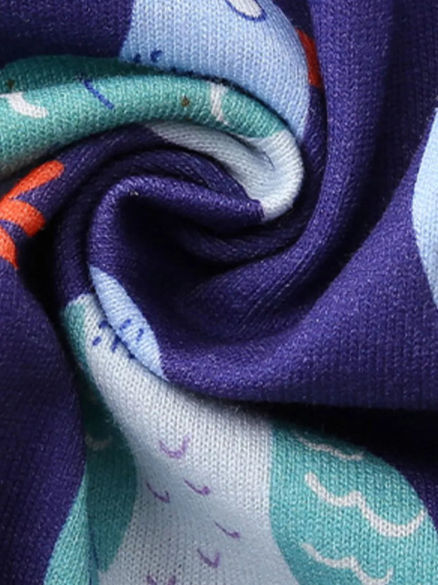 Toddler dress in cotton with a playful pigeon print in blue, teal, and orange on a purple background.