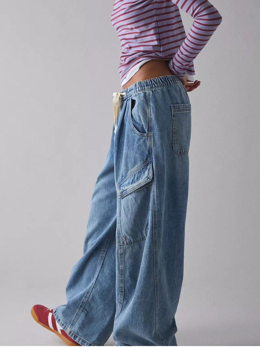 Drawstring waist cargo jeans in dusty blue denim with multiple pockets and a relaxed fit.