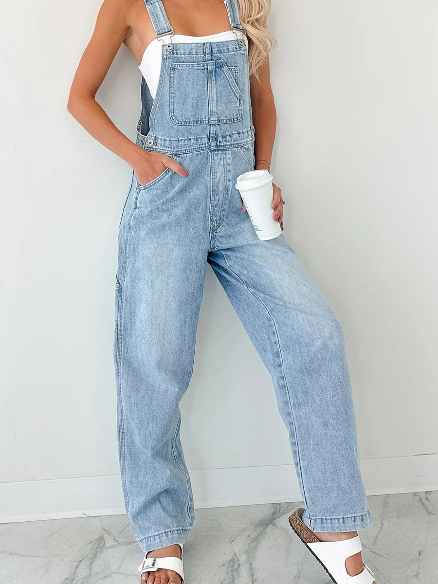 Light wash denim overalls with wide straps, relaxed fit, bib pocket, and front pockets.
