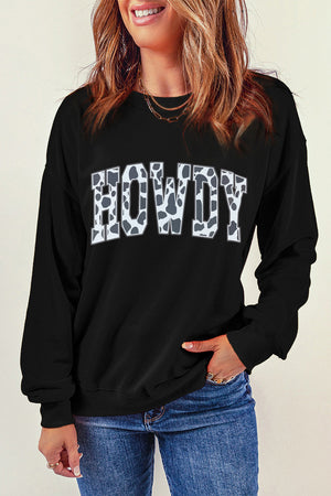 Black crewneck sweatshirt with cow print "Howdy" graphic.