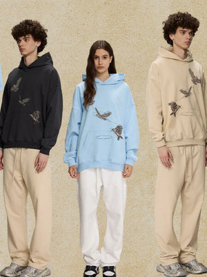 Light blue relaxed fit hoodie with embroidered birds graphic and front pocket.
