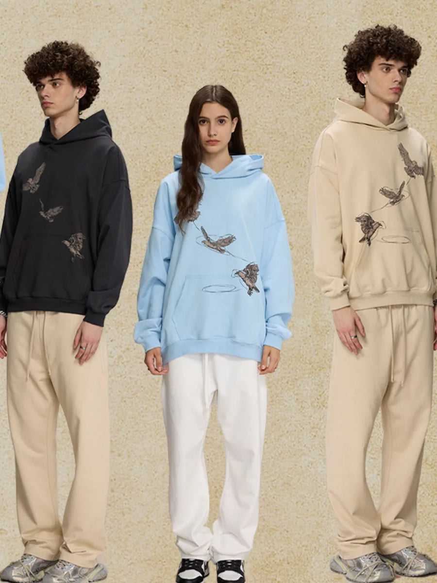 Light blue relaxed fit hoodie with embroidered birds graphic and front pocket.