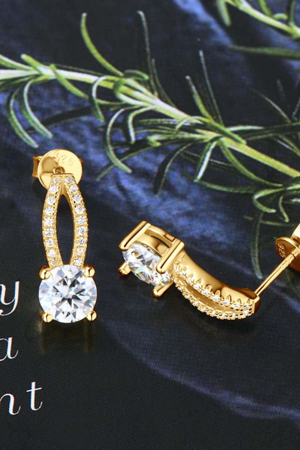 Gold drop earrings with clear stones and a curved bar detail.