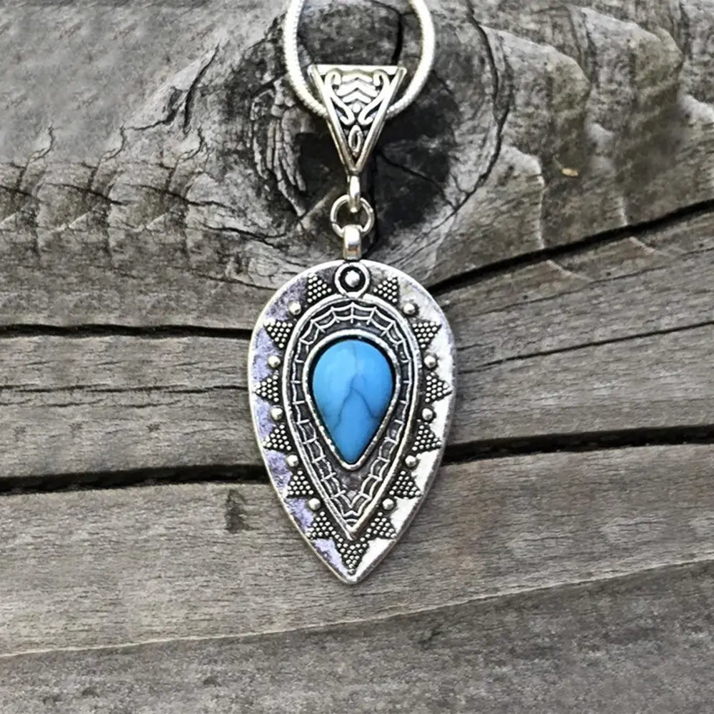 Silver teardrop necklace with turquoise inlay and boho detailing.
