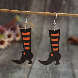 Black witch boot silhouette drop earrings with orange stripes and a small orange dot detail.