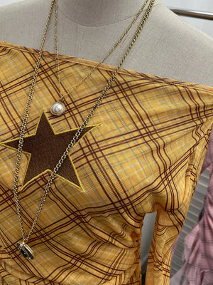 Yellow plaid asymmetrical ruffle hem t-shirt with a star cutout detail.