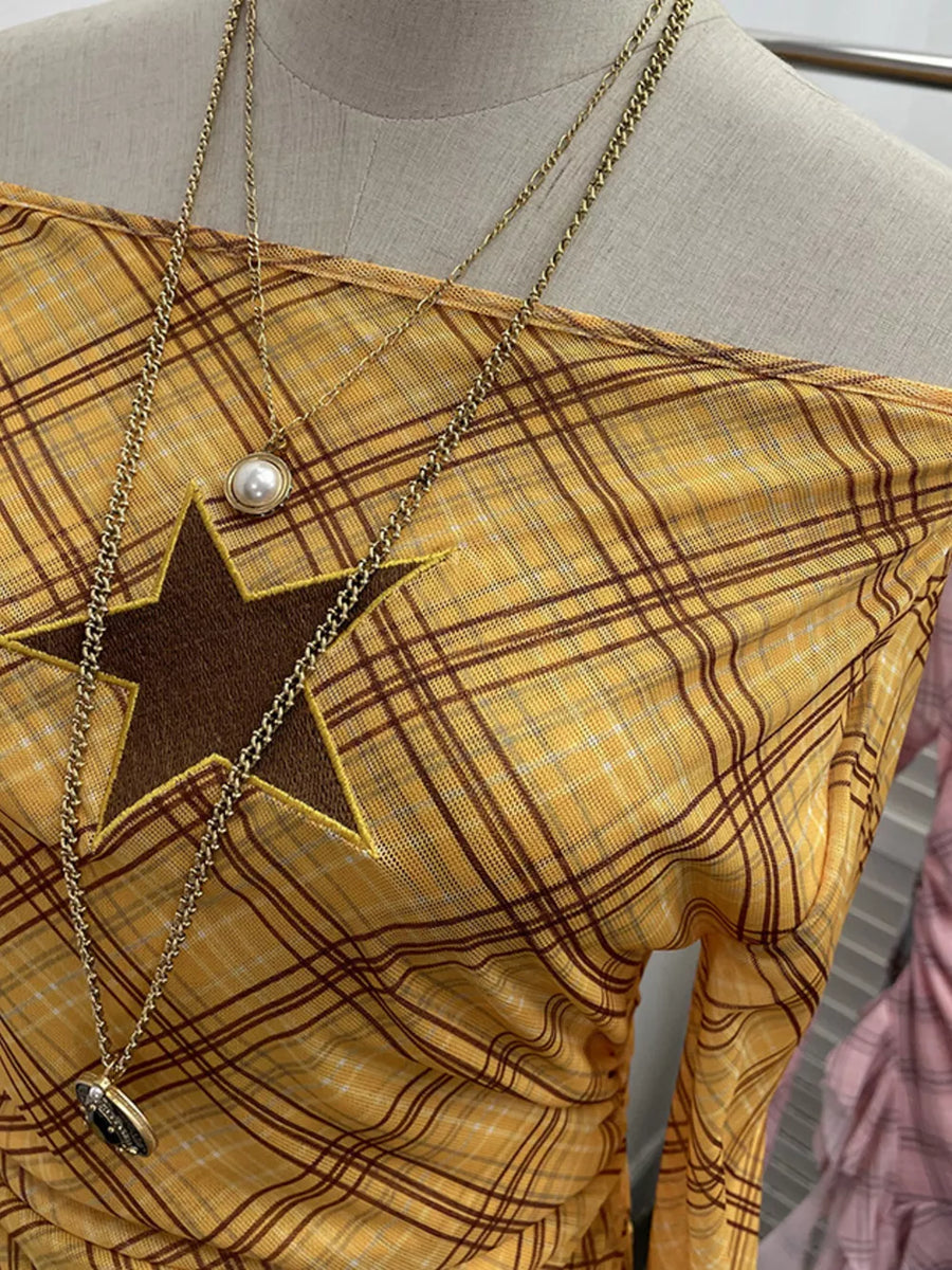 Yellow plaid asymmetrical ruffle hem t-shirt with a star cutout detail.