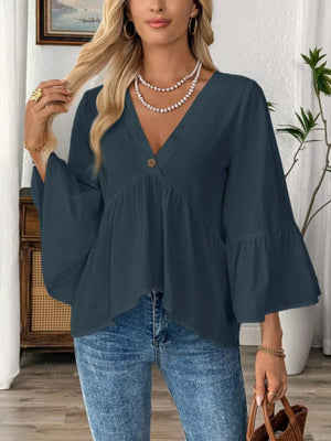 Navy blue cotton V-neck blouse with bell sleeves and a button detail.