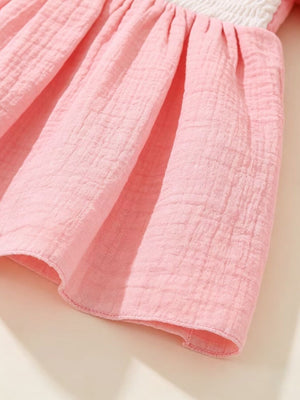 Pink baby dress with smocked bodice and textured cotton skirt