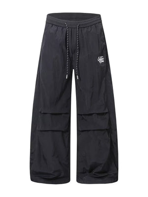 Black wide-leg cargo pants with drawstring waist and large side pockets.
