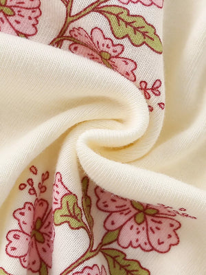 Charming floral cotton dress for toddlers in beige, featuring pink flowers and green leaves.