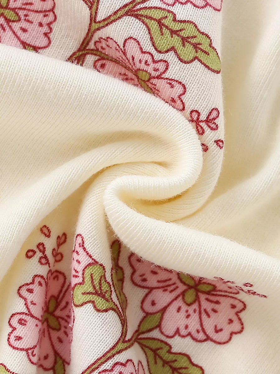Charming floral cotton dress for toddlers in beige, featuring pink flowers and green leaves.