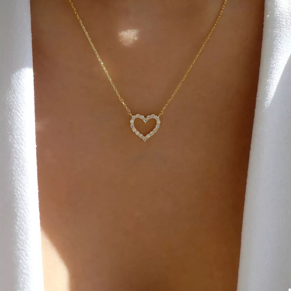 Elegant gold heart pendant necklace with clear stones on a delicate chain