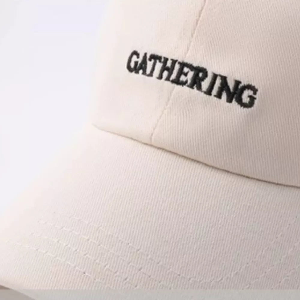Beige cotton baseball cap with embroidered "GATHERING" text
