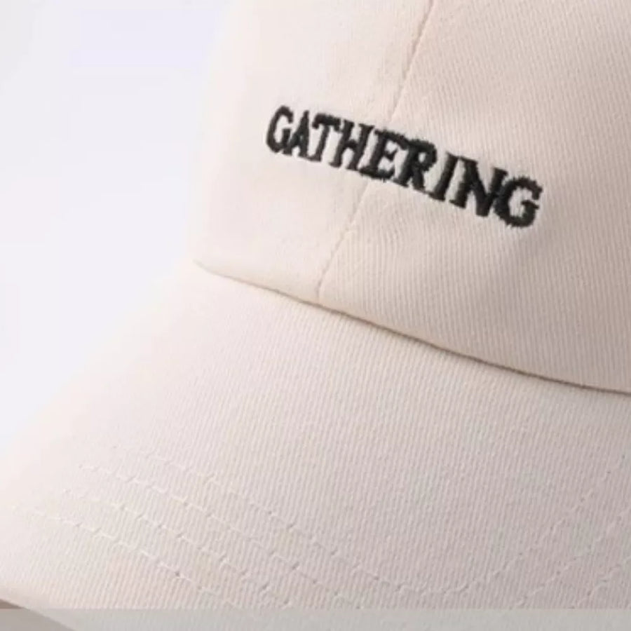 Beige cotton baseball cap with embroidered "GATHERING" text