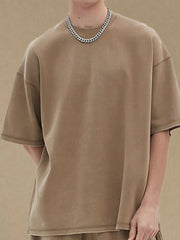 Khaki half sleeve tee with crewneck and relaxed fit, styled with a chain necklace.