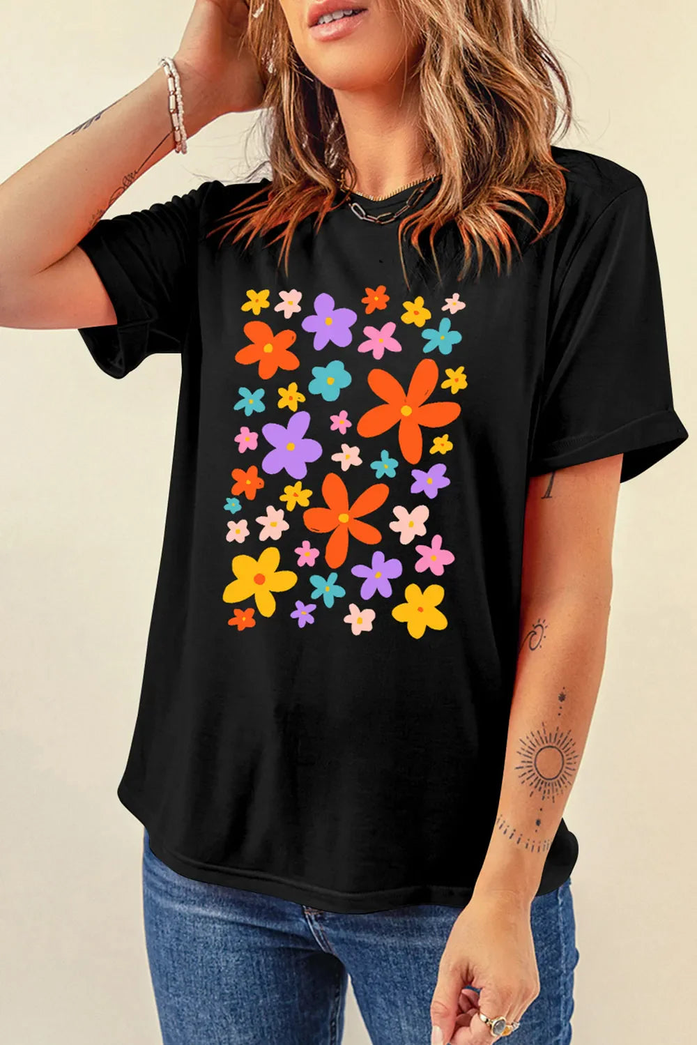 Black round neck tee with a colorful bloom print and short sleeves.