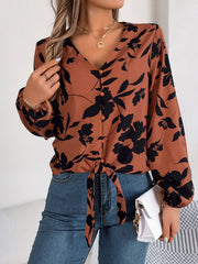 Brown floral knot-front blouse with V-neck and button detail.