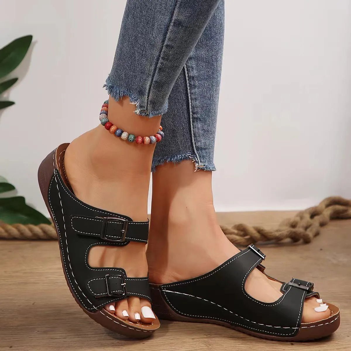 Black double-strap buckle slides with white stitching and contoured footbed.