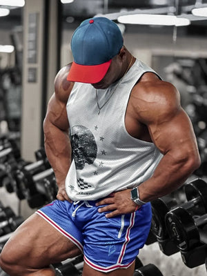 White perforated tank top with skull graphic, blue athletic shorts with white and red trim