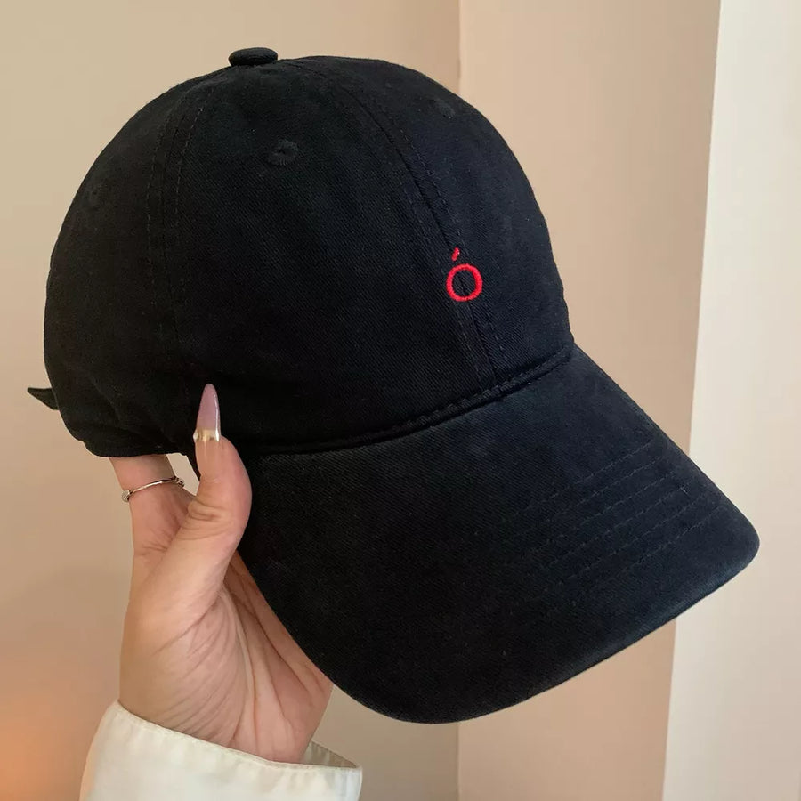 Black cotton baseball cap with curved brim and red embroidered logo detail.