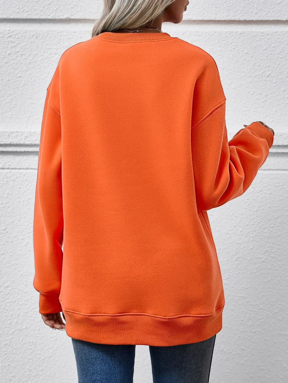 Orange drop shoulder sweatshirt with crew neck and ribbed cuffs and hem.
