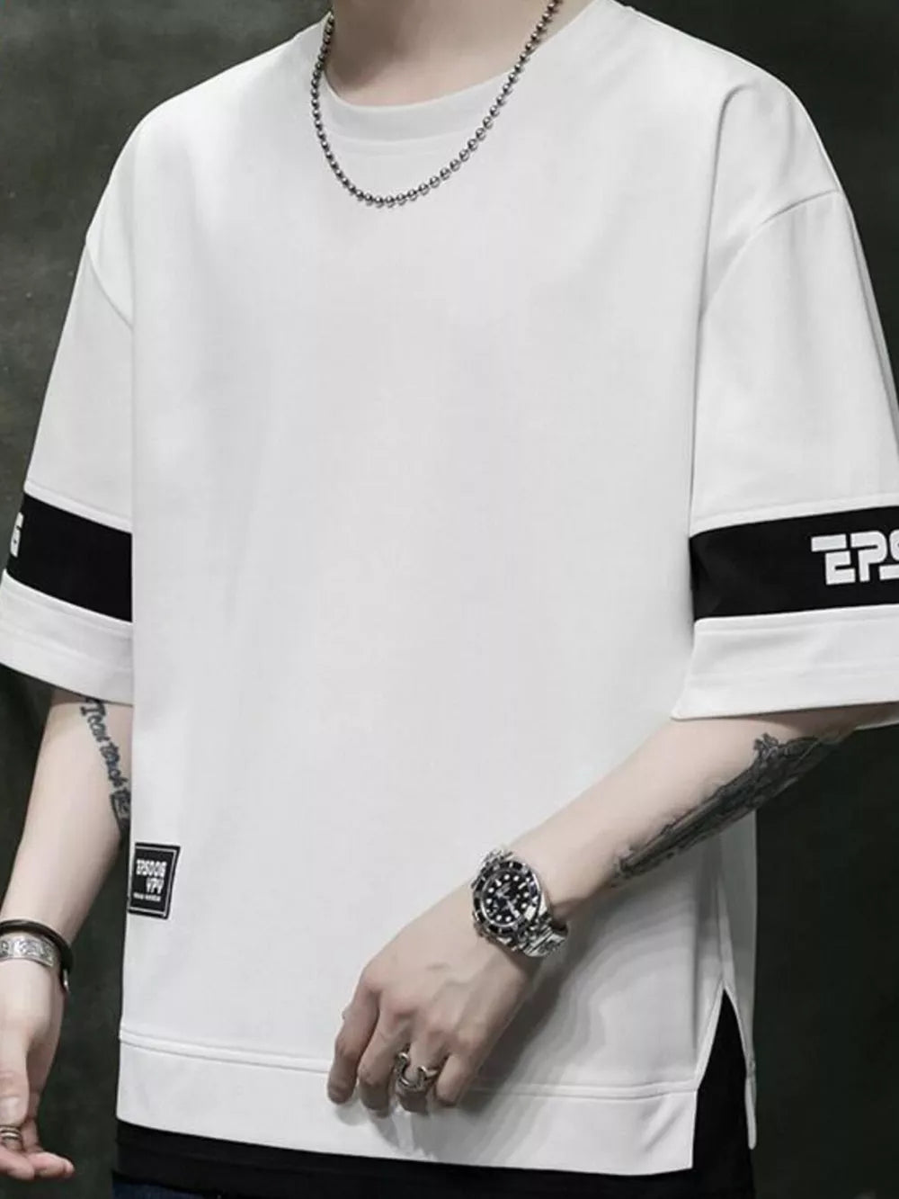 White oversized t-shirt with black contrast sleeve bands and graphic detail.