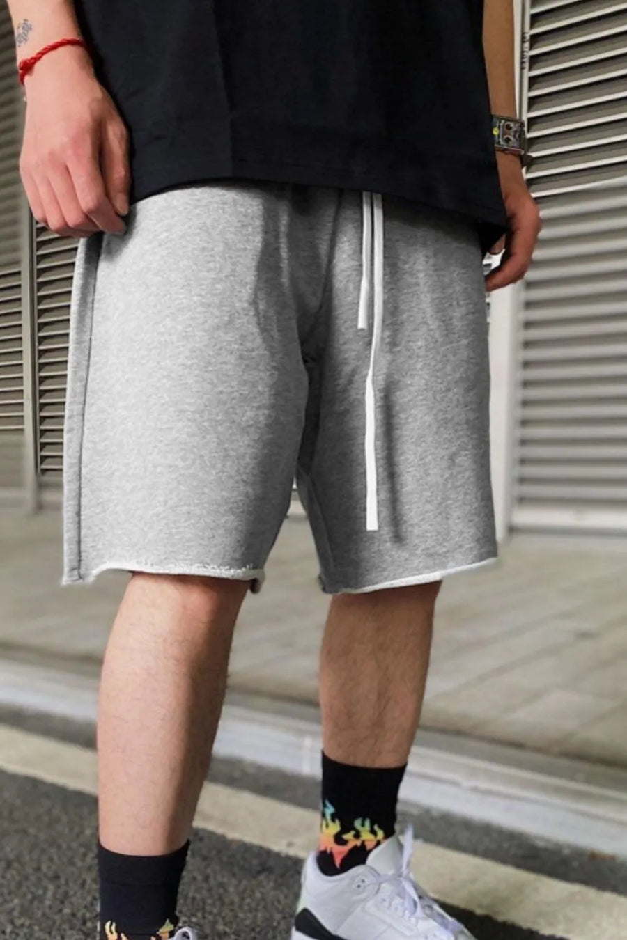 Gray relaxed fit jogger shorts with raw hem and white drawstring