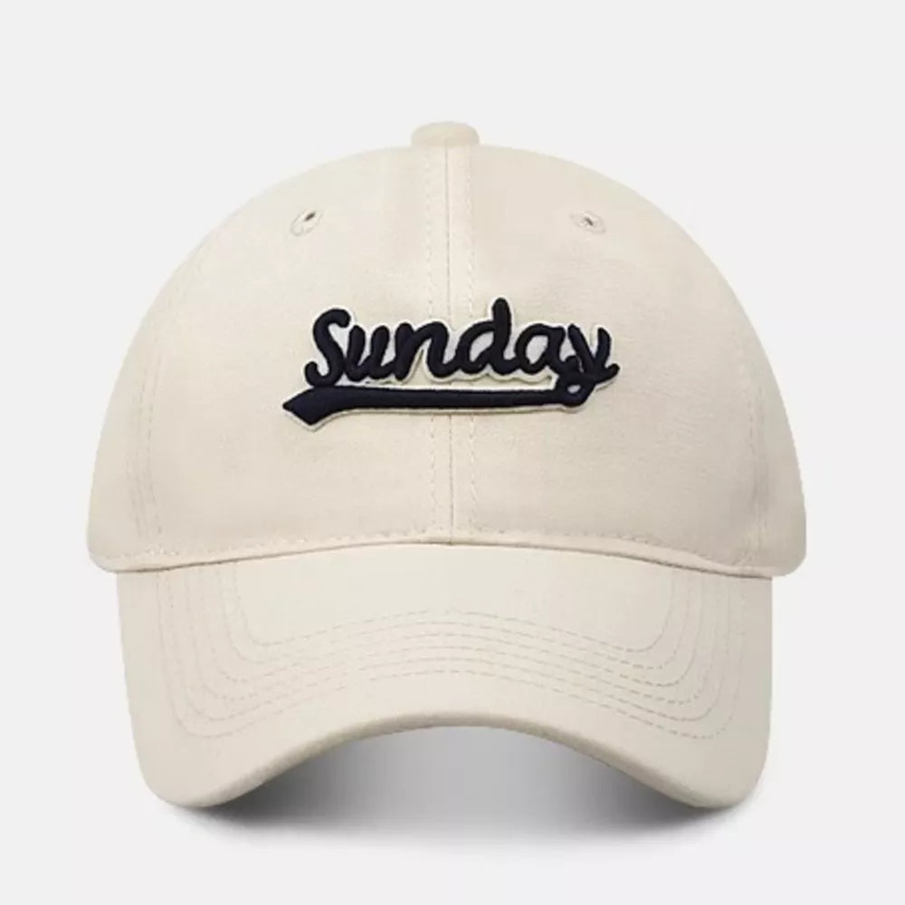 Cream baseball cap with navy blue embroidered "Sunday" text and curved brim.