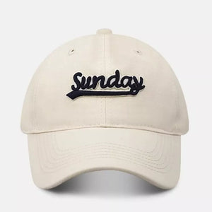Cream baseball cap with navy blue embroidered "Sunday" text and curved brim.