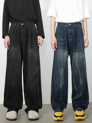 Pleated wide-leg distressed denim trousers in dark and medium wash, featuring a relaxed fit.