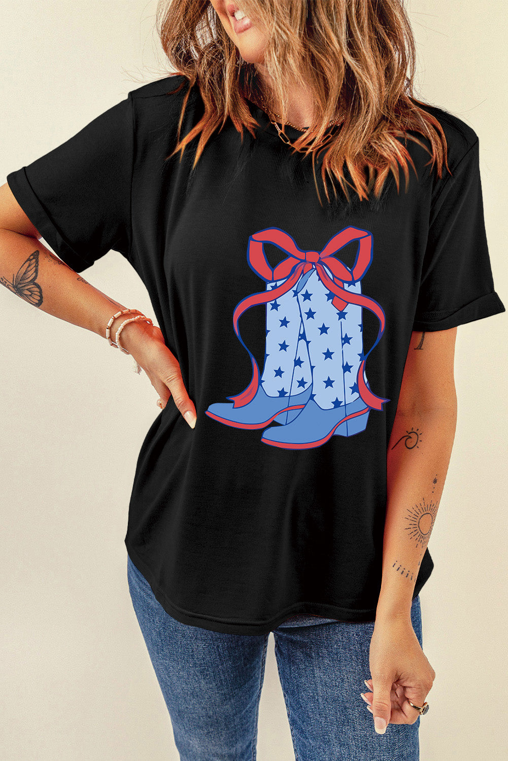 Black t-shirt with a cowboy boot bow graphic featuring blue boots with stars and a red bow.