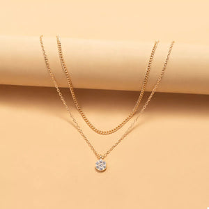 Gold double layered pendant necklace with small crystal charm