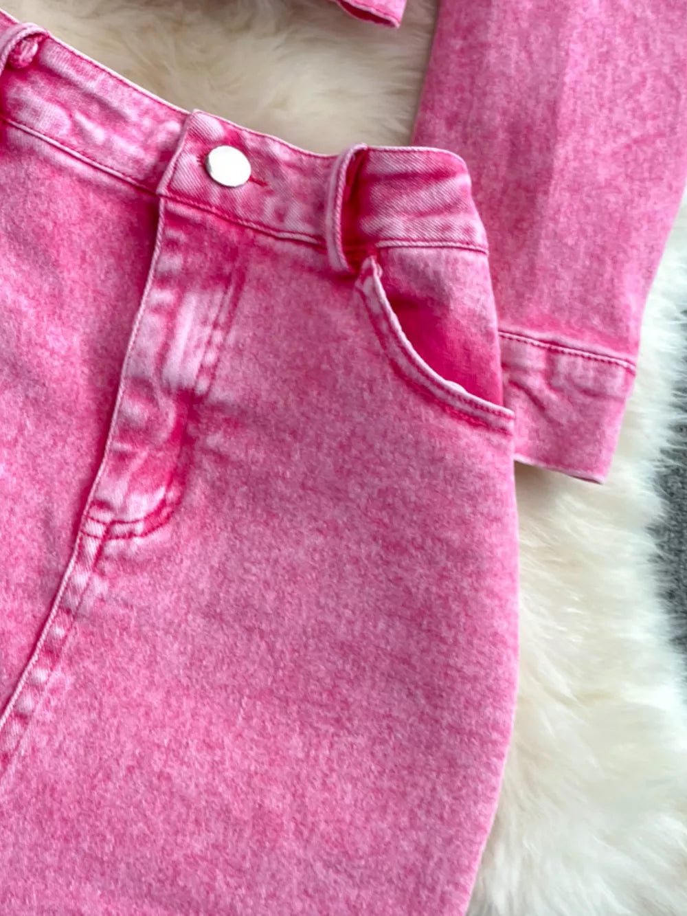 Pink acid wash denim jacket and skirt set with button details and pocket.