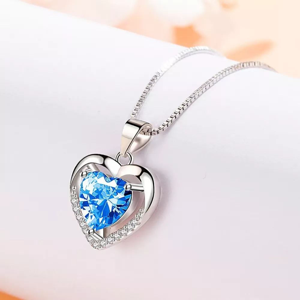 Elegant heart pendant necklace with blue zircon and diamonds on a silver chain.
