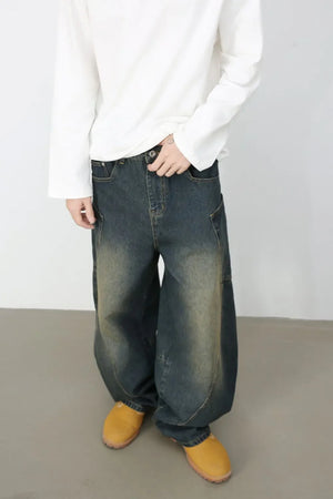 Sculpted denim balloon trousers in dark wash with a relaxed fit and visible stitching details.