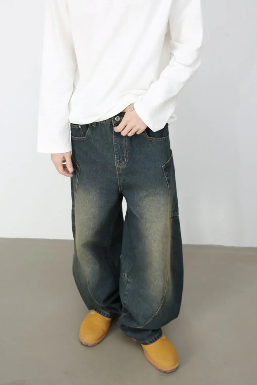 Sculpted denim balloon trousers in dark wash with a relaxed fit and visible stitching details.